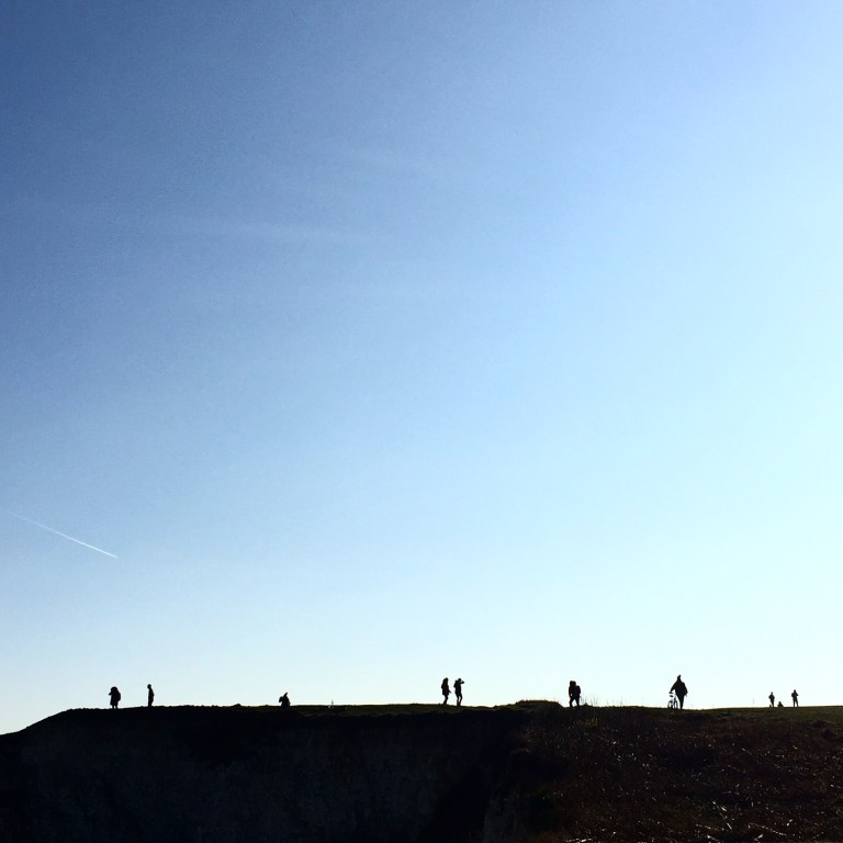 Silhouetted figures at Old Harry Rocks, near Swanage, Dorset