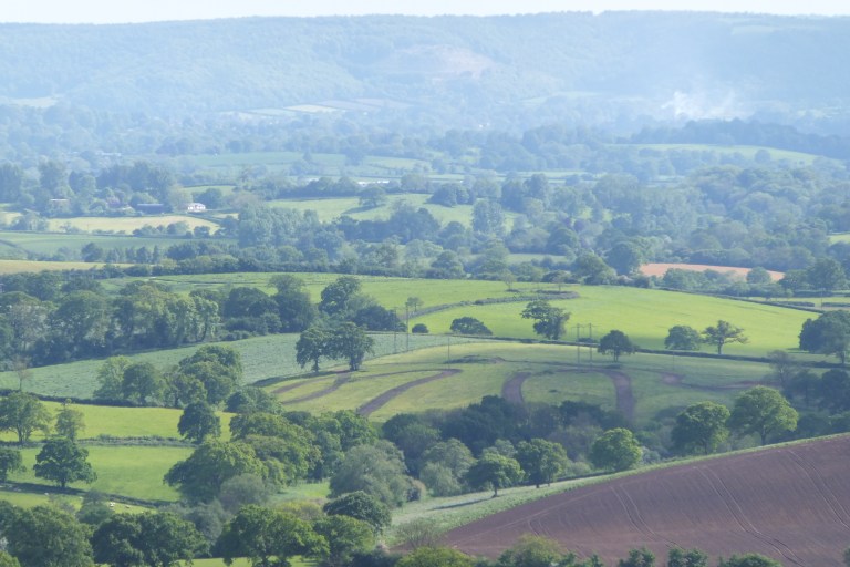 The green, rolling hills of the Dorset countryside as seen from Park Walk in Shaftesbury, Dorset, UK