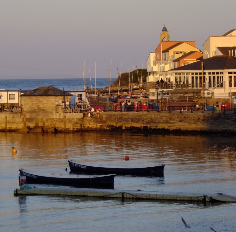 A sunset view of the boats and buildings at Peveril Point, Swanage, Dorset, UK