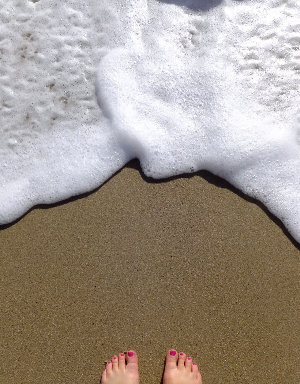 A swimmer's feet on a sandy beach