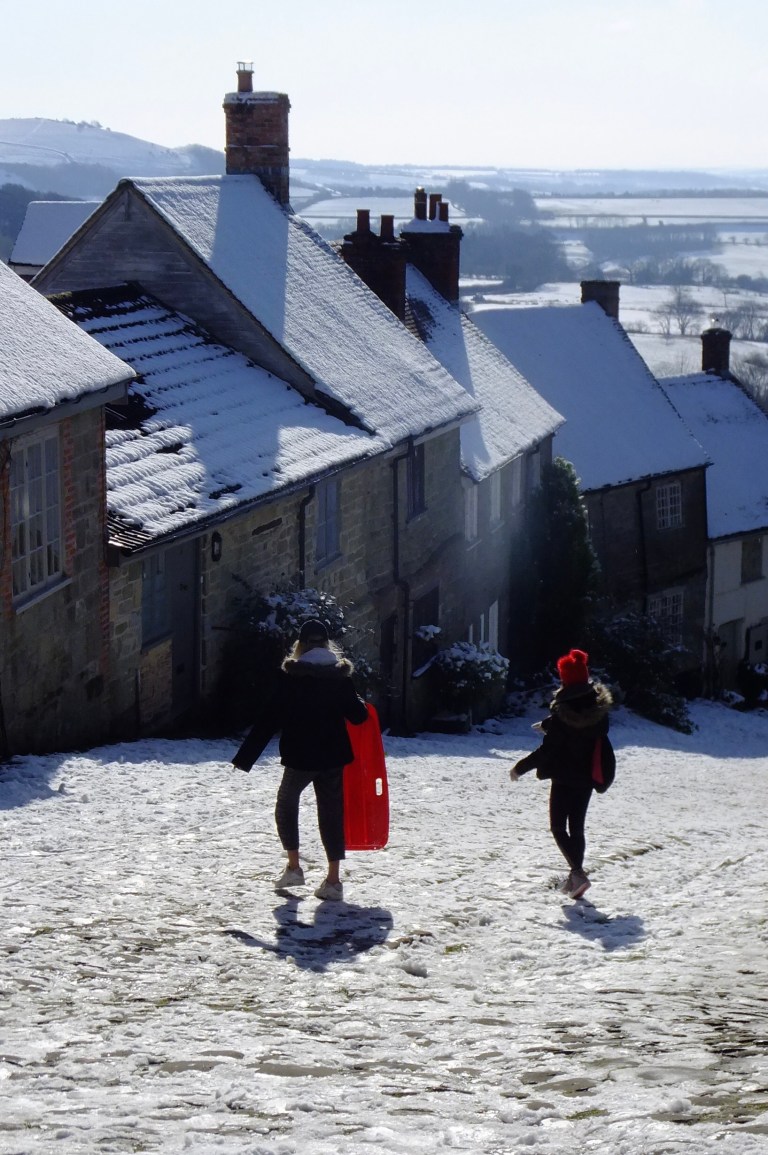 Two girls sledging down Hovis Hill, Shaftesbury, Dorset
