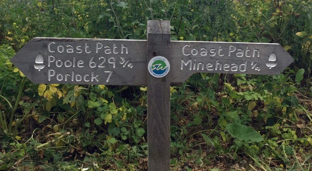 South West Coast Path sign showing distance between Minehead and Poole